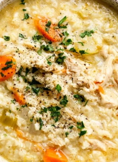 Bowl of homemade Chicken Rice Soup with carrots and herbs