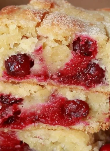 A delicious Cranberry Christmas Cake garnished with fresh cranberries and icing.