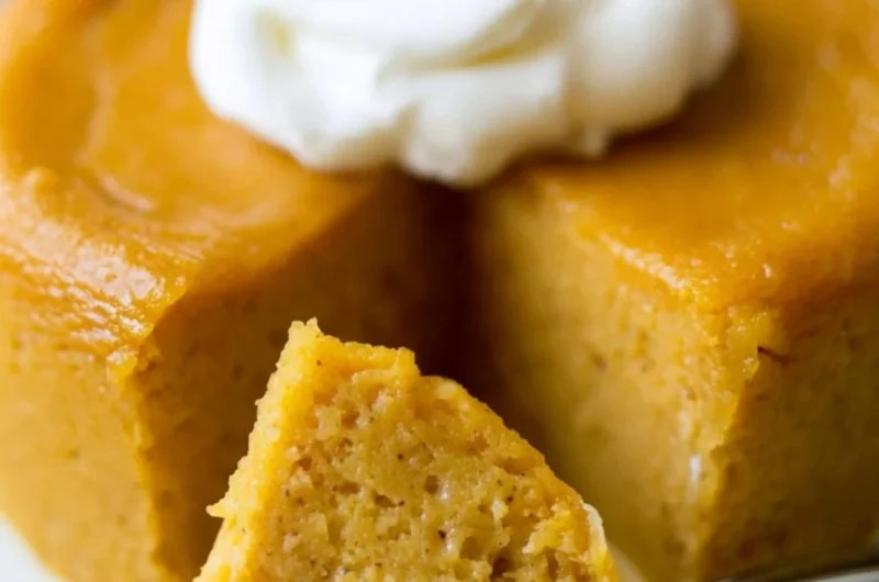 A slice of Crustless Pumpkin Pie Pudding served on a plate with whipped cream.