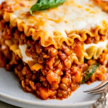 Plate of easy vegan lentil lasagna topped with fresh herbs and cheese alternatives