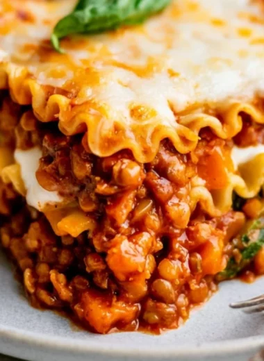 Plate of easy vegan lentil lasagna topped with fresh herbs and cheese alternatives