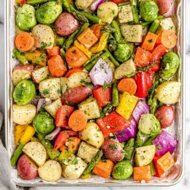A colorful plate of oven-roasted vegetables, including carrots, bell peppers, and zucchini.