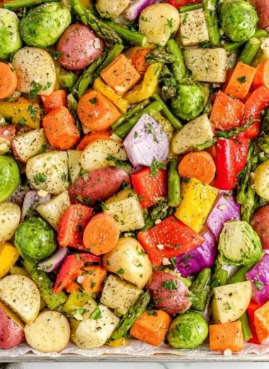 A colorful plate of oven-roasted vegetables, including carrots, bell peppers, and zucchini.
