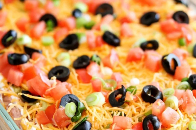 Delicious ultimate seven layer bean dip served in a colorful dish