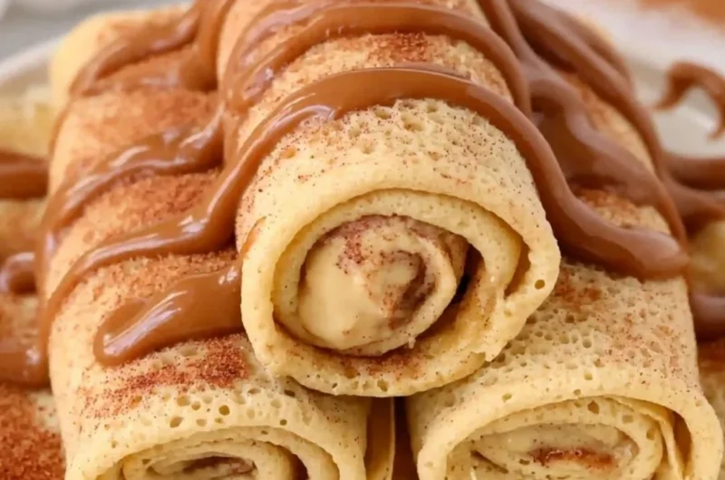 Delicious cinnamon roll protein crepes served with creamy topping and cinnamon drizzle.