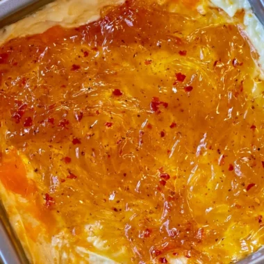 Delicious baked Pepper Jelly Cheese Dip served with crackers and veggies.