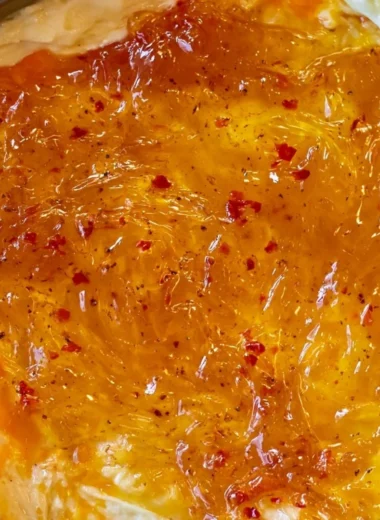Delicious baked Pepper Jelly Cheese Dip served with crackers and veggies.