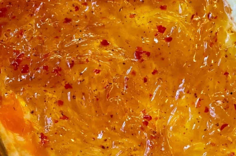 Delicious baked Pepper Jelly Cheese Dip served with crackers and veggies.