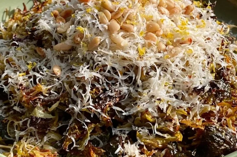 A plate of roasted shredded Brussels sprouts garnished with herbs.