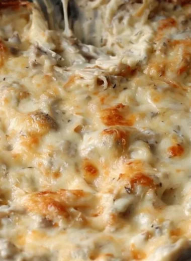 Delicious stuffed mushroom dip served in a bowl, garnished with herbs.