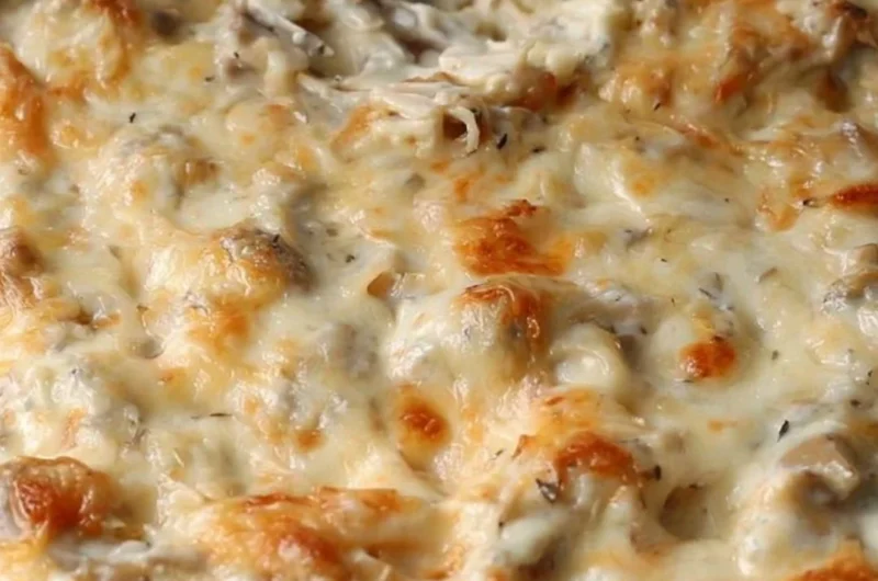 Delicious stuffed mushroom dip served in a bowl, garnished with herbs.
